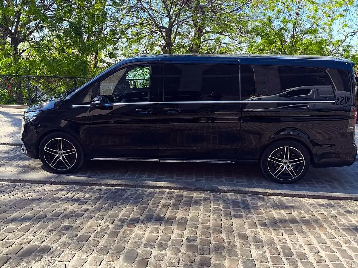 Mercedes Clase V con chófer dedicado, aparcada en una calle adoquinada